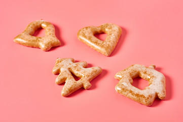 Various festive christmas cookie scattered on pink background. New year celebration concept