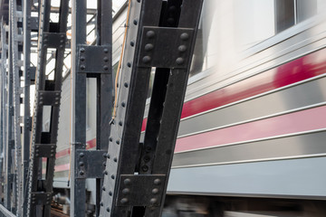 The train runs through the railway bridge. Blurred.
