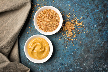 Set of yellow mustard sauce and seeds in small bowls