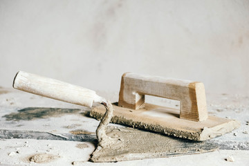 Old construction tools for plaster on vintage wood bench. Trowels and other masonry tools. Copy,...