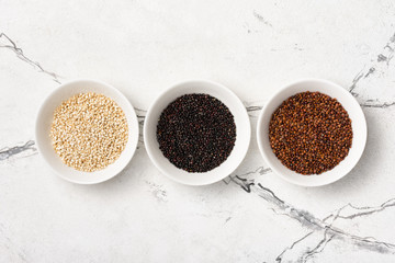 Set of white, red and black quinoa seeds in bowls