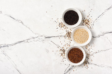 Obraz na płótnie Canvas Set of white, red and black quinoa seeds in bowls