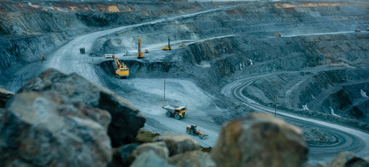 Work of trucks and the excavator in an open pit