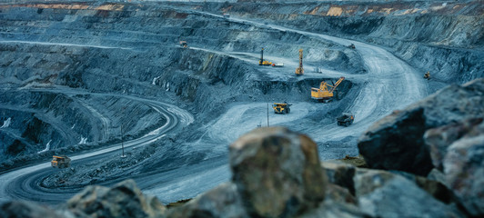 Work of trucks and the excavator in an open pit