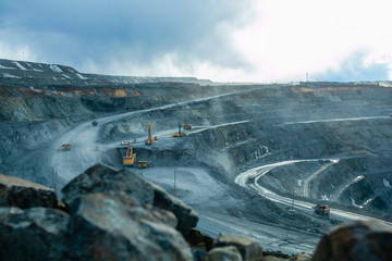 Work of trucks and the excavator in an open pit