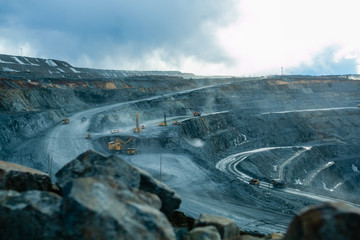 Work of trucks and the excavator in an open pit © evgenii_v
