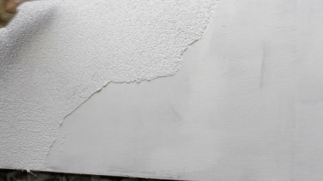 builder plasterers the wall of the house,the painter finishes a facade with white plaster the crumb puts a spatul