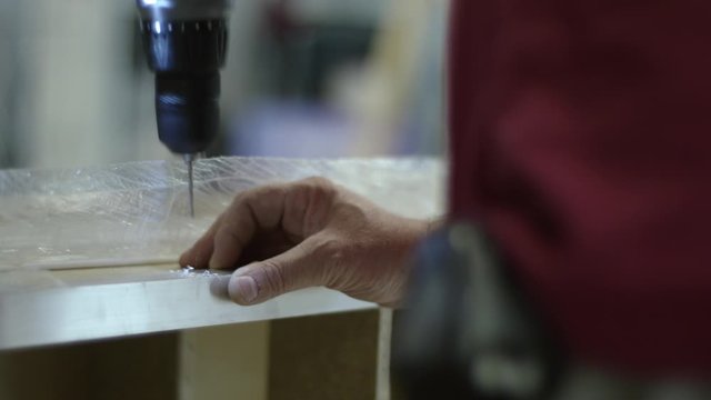 a man drills a metal profile with a drill.