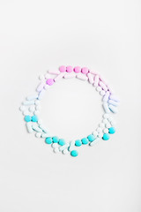 creative medicine compositions. the frame of tablets and capsules, different shapes on a white background. vitamins for skin, hair, and nails. flat lay, vertical frame