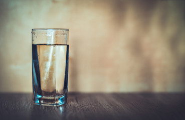 Glass of water on a wooden background