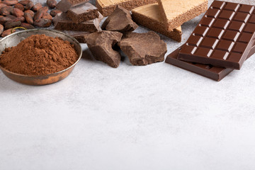 Assortment of different chocolate types on concrete background. Copy space.  Food background.