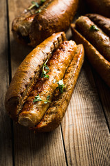 Tasty fresh hot dogs with grilled sausage on the rustic background. Selective focus. Shallow depth of field.