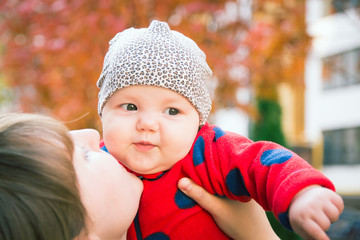 Loving mother kisses her little beautiful baby