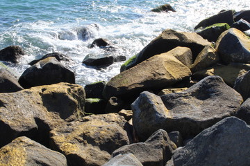 Sea water splashes and rocks on the beach