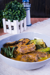 kare kare; a mix of ox tail and tripe with vegetables like eggplant, sitaw (long bean), pechay, puso ng saging stewed in peanut sauce and serve with shrimp paste for additional flavor