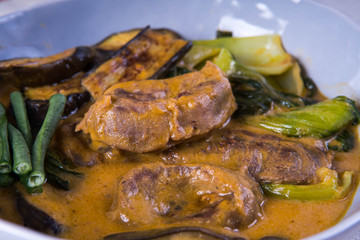 kare kare; a mix of ox tail and tripe with vegetables like eggplant, sitaw (long bean), pechay, puso ng saging stewed in peanut sauce and serve with shrimp paste for additional flavor