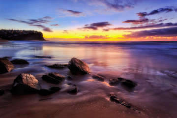 Sea Bungan beach dark rocks in sand