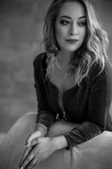 A beautiful girl in a dress looks into the distance шт the room. Black & white.