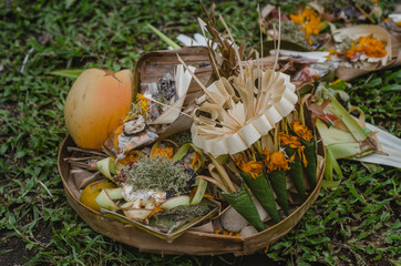 Traditional Balinese offerings to Hindu gods in Bali with flowers and incense sticks