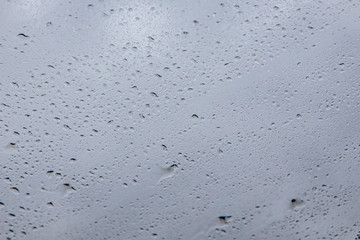 Wet drops of water on the glass. Close up photo of rain