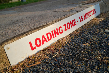 Loading zone sign on the footpath