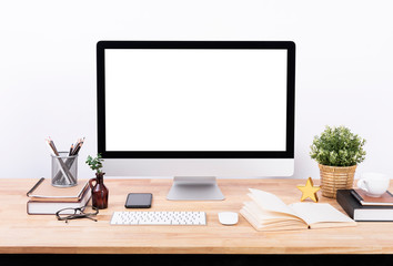 Mockup Blank screen desktop computer and decorations on wood table and white wall background.