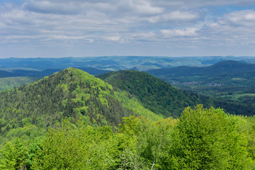 Obraz premium Green mountain forest landscape under the blue sky with clouds in Germany, panoramic view of Germany countryside