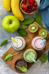 The concept of a healthy diet. Detox smoothies mix. Green smoothies vegetable and fruit smoothies on a stone concrete worktop. Top view flat lay background.