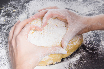 Fototapeta premium woman hands in form of heart on fresh dough