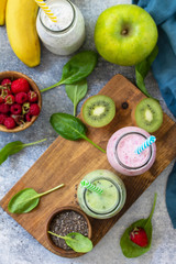 The concept of a healthy diet. Detox smoothies mix. Green smoothies vegetable and fruit smoothies on a stone concrete worktop. Top view flat lay background.