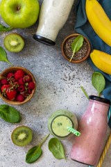 The concept of a healthy diet. Detox smoothies mix. Green smoothies vegetable and fruit smoothies on a stone concrete worktop. Top view flat lay background. Copy space.
