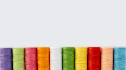 Top view laying out multi-colored threads on an isolated background, copy space. Needlework concept, handmade, homemade.