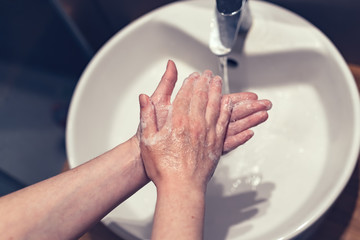 Woman washing hands in bathroom