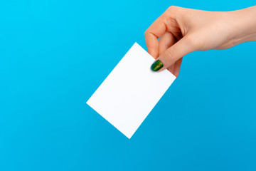 Woman hand holding blank card on blue background