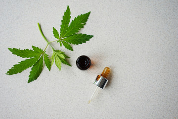 
medical bottle made of dark glass with leaves of hemp. The concept of the use of hemp for medical purposes