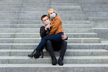 Young couple in love in protective medical mask on face outdoor at street. Environmental pollution concept. Guy and girl in virus protection