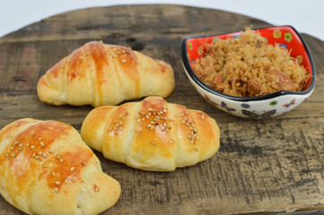 Serbian homemade rolls, kiflice, with a bowl of greaves on the rustic background, selective focus