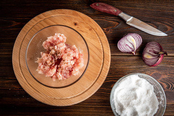 Minced chicken on wooden board.