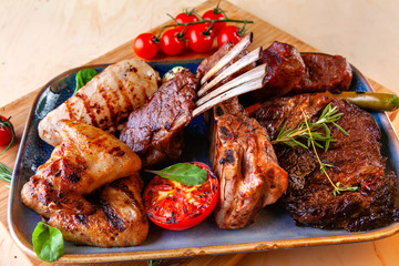 different types of meat with tomatoes and zucchini in a plate