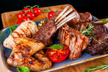 different types of meat with tomatoes and zucchini in a plate