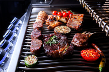 different types of meat with tomatoes and zucchini on the grill