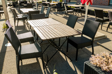 Restaurant with empty chairs and tables in the evening sun during curfew at Corona