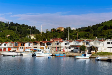 Fototapeta na wymiar TRABZON, TURKEY - JULY 06, 2012: Fishing Shelter, Boats, Green hills and Buildings. Of District