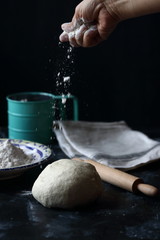 Fototapeta premium Dough ,making dough with flour on a black background, bread and pizza dough