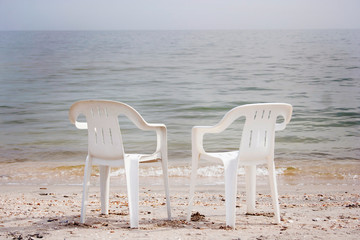 Picture of two chairs standing on seaside beach near calm sea