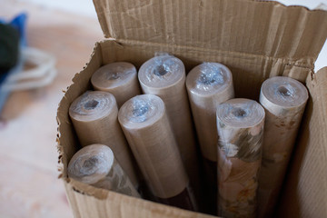 wallpaper rolls lying in a cardboard box