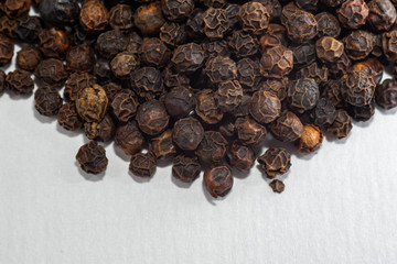 Close-up of a pile of black pepper isolated on a white background selective focus, copy space, macro