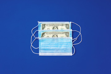 Fototapeta na wymiar Close up of medical protective masks and american dollar banknotes on blue background