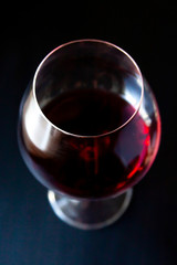 Wine glass with red wine shot with a shallow depth of field on a dark blue gradient background