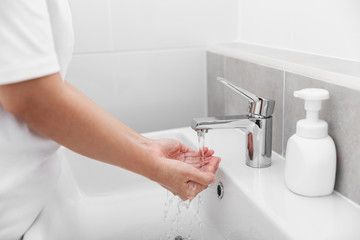 Woman use soap and washing hands under the water tap for corona virus prevention.